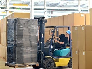 man driving forklift with boxes warehouse operative training